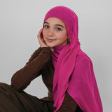 Person wearing a bright pink hijab and brown outfit on a plain background