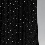 Black hijab fabric with white polka dots on a gray background