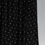 Black hijab fabric with white polka dots on a gray background