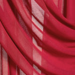 A close-up of draped red sheer fabric with soft folds and translucent texture.