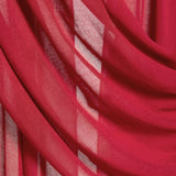 A close-up of draped red sheer fabric with soft folds and translucent texture.