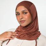 Woman wearing a canyon brown ruching hijab with a taupe top
