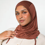 Woman wearing a canyon brown ruching hijab with a taupe top