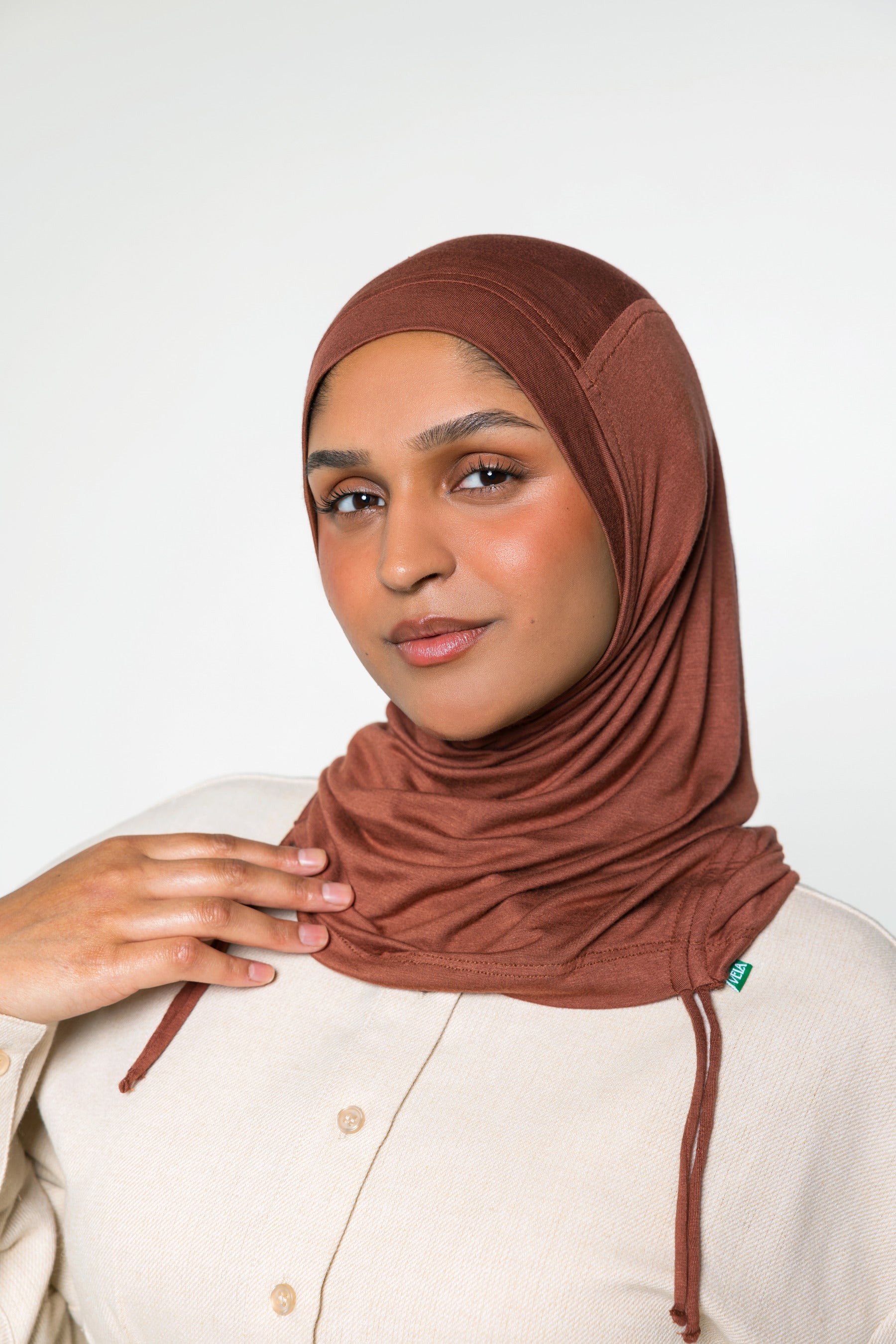Woman wearing a canyon brown ruching hijab with a taupe top