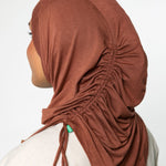 Woman wearing a canyon brown ruching hijab with a taupe top