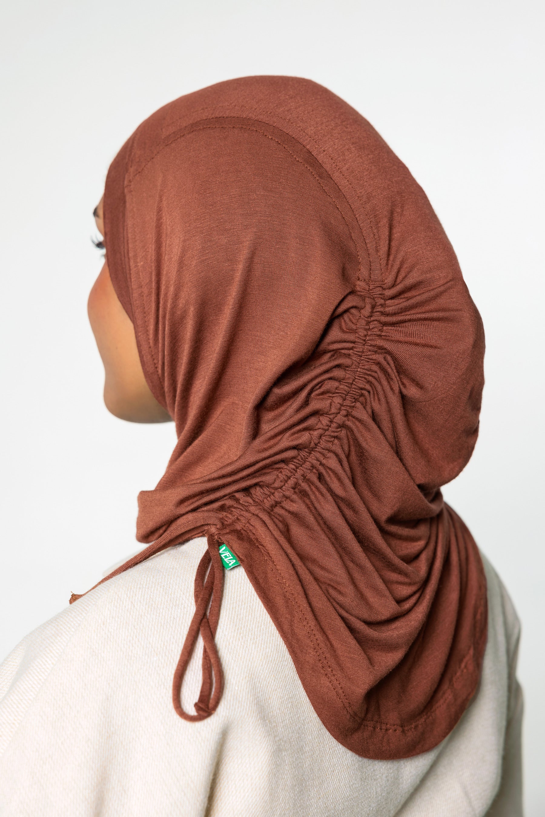 Woman wearing a canyon brown ruching hijab with a taupe top