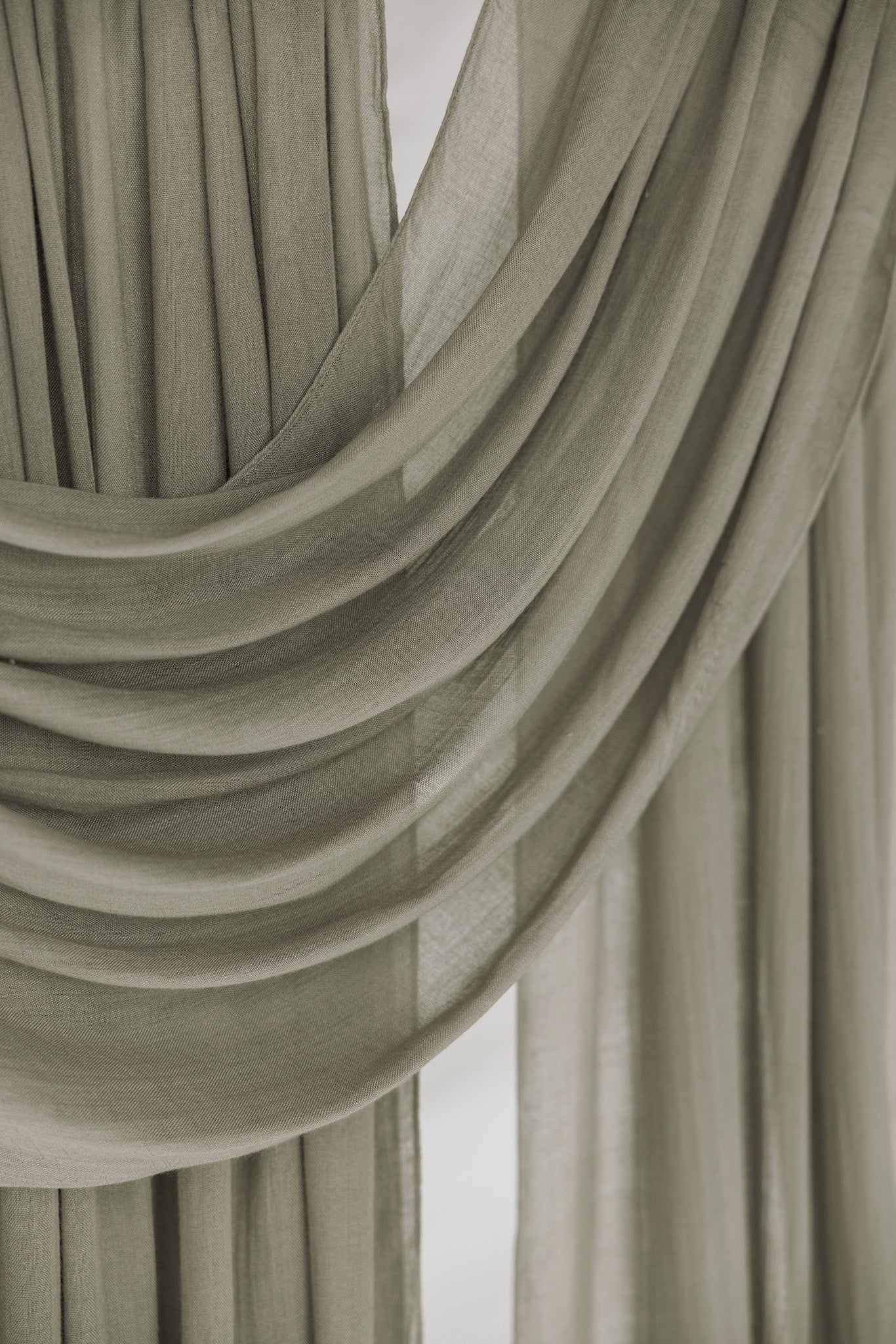Close-up of draped desert sage fabric with a neutral background