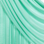 A close-up of draped mint green fabric with soft folds and a subtle sheen, set against a light neutral background.