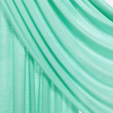 A close-up of draped mint green fabric with soft folds and a subtle sheen, set against a light neutral background.