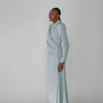 Woman wearing a silver ruched abaya with a white background