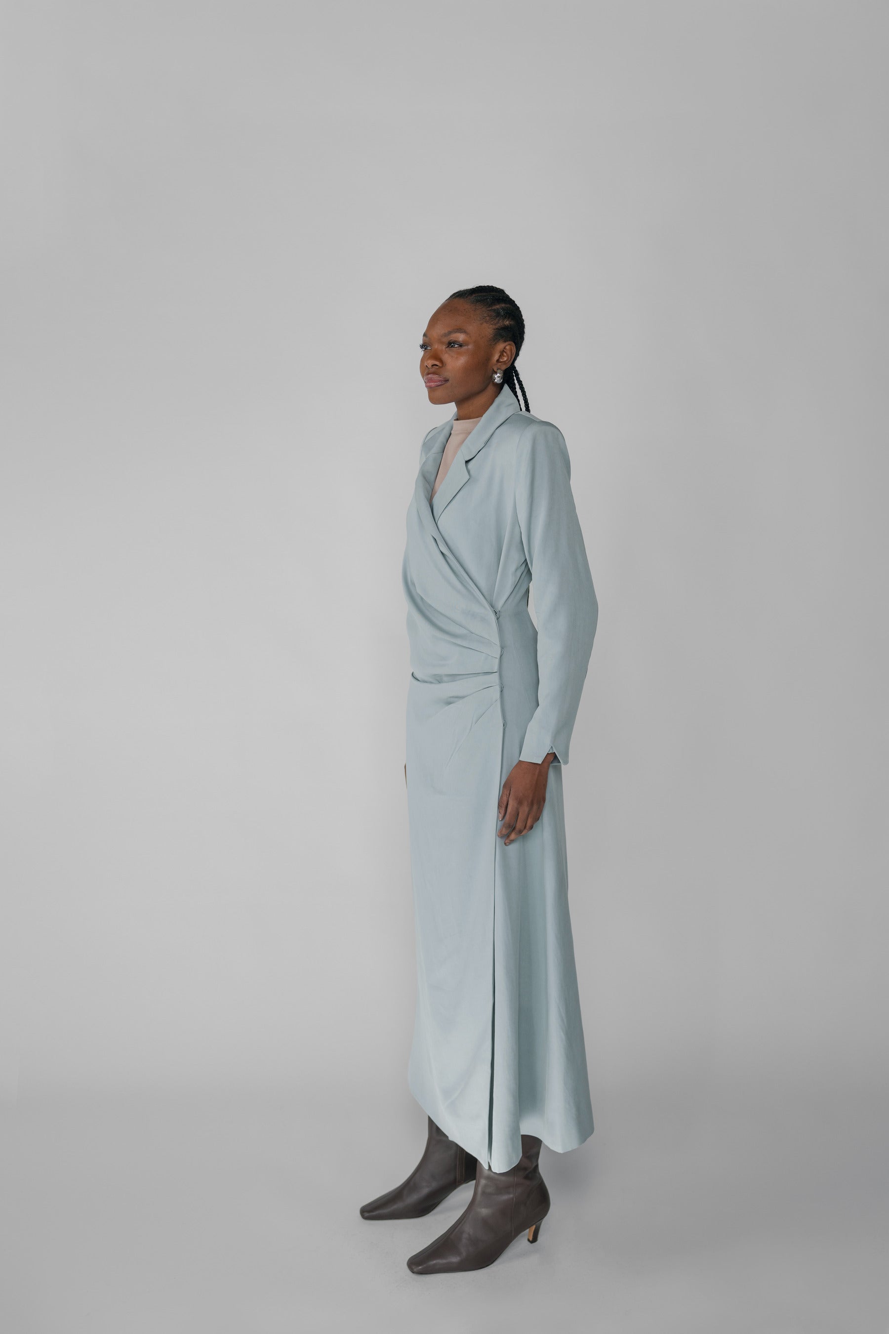 Woman wearing a silver ruched abaya with a white background