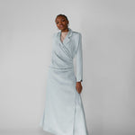 Woman wearing a silver ruched abaya with a white background