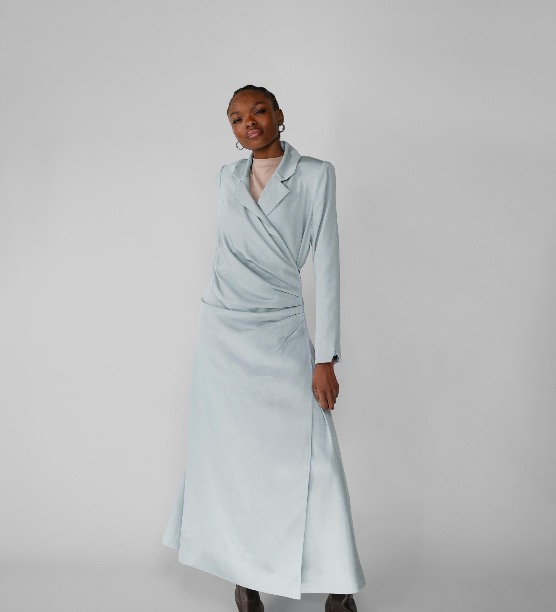 Woman wearing a silver ruched abaya with a white background