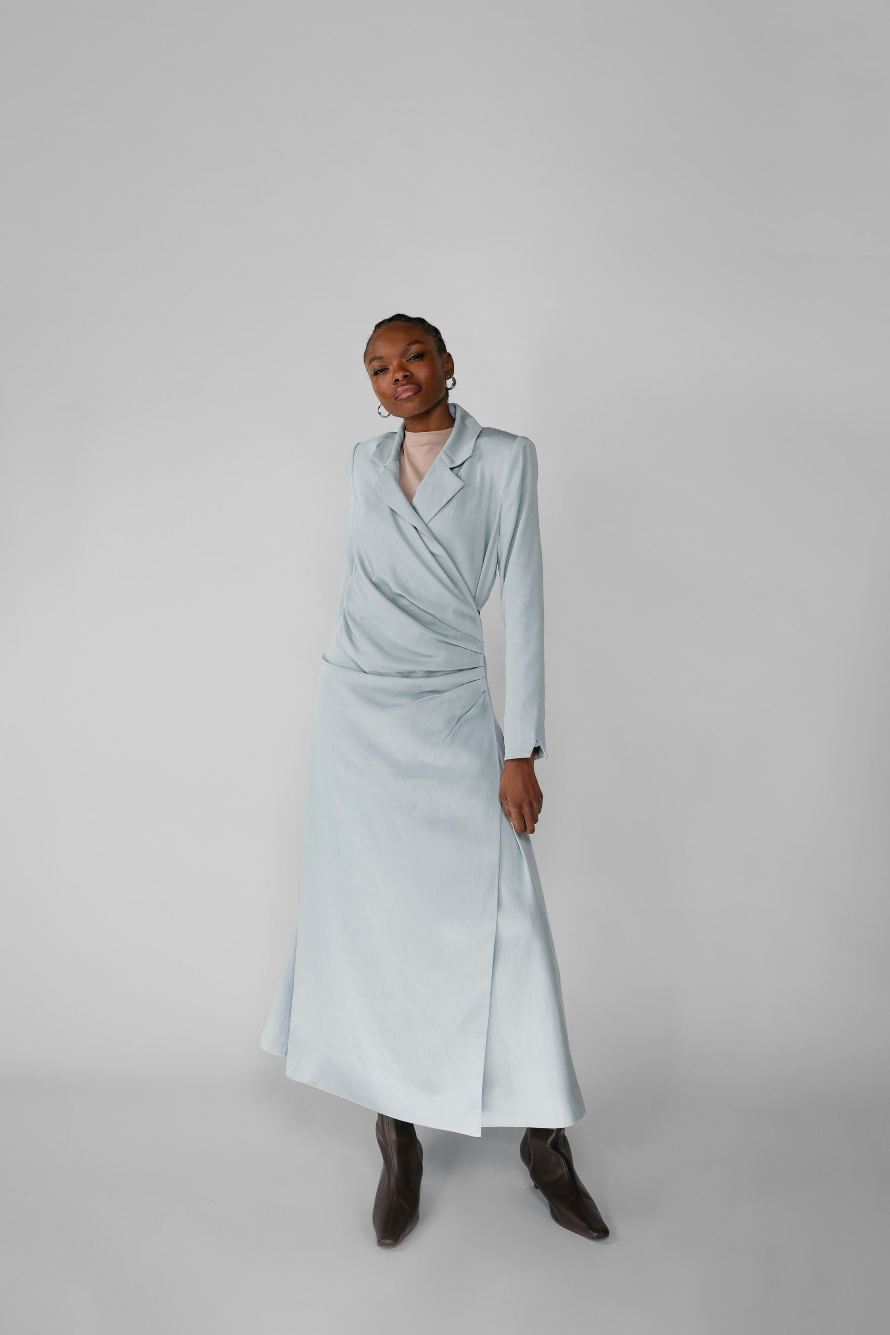 Woman wearing a silver ruched abaya with a white background
