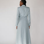 Woman wearing a silver ruched abaya with a white background