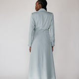 Woman wearing a silver ruched abaya with a white background