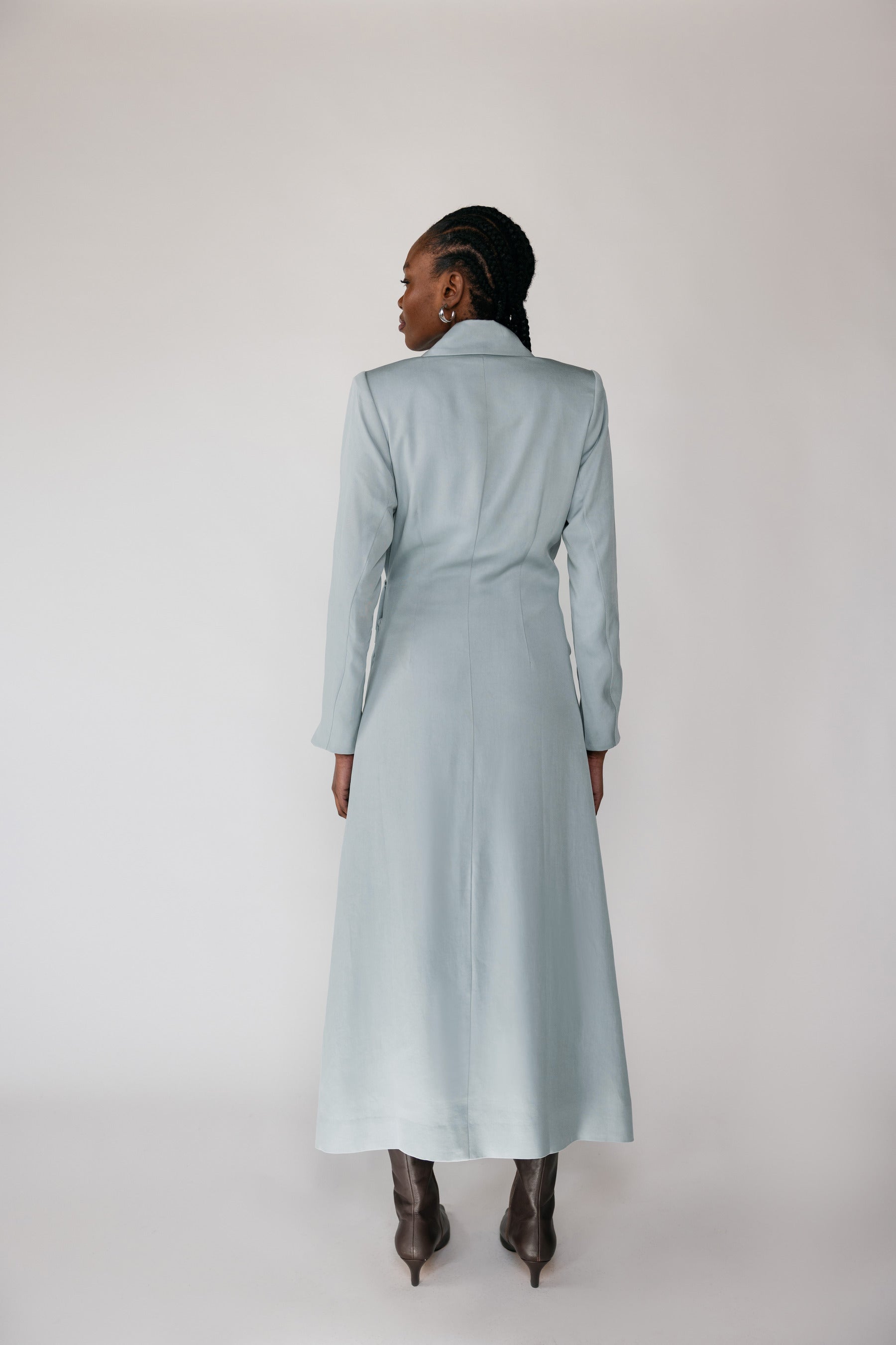 Woman wearing a silver ruched abaya with a white background