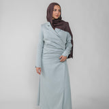 Woman wearing a silver ruched abaya with a white background