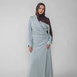 Woman wearing a silver ruched abaya with a white background