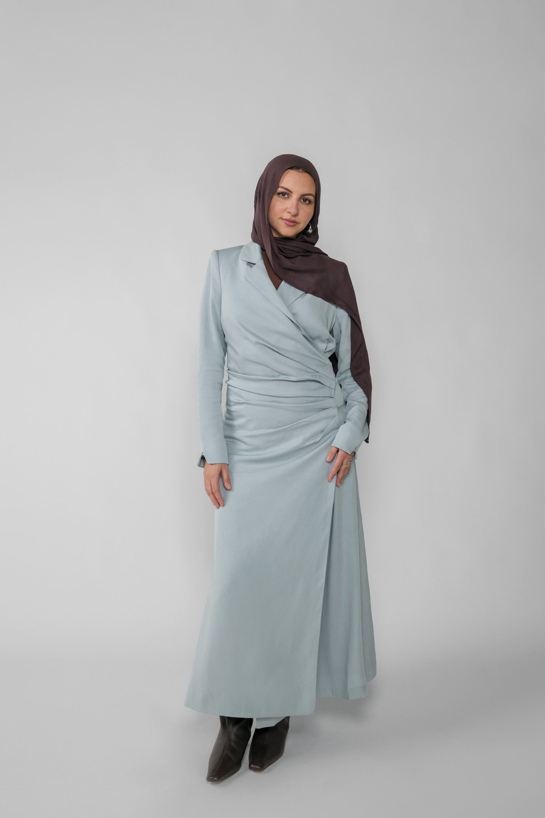 Woman wearing a silver ruched abaya with a white background