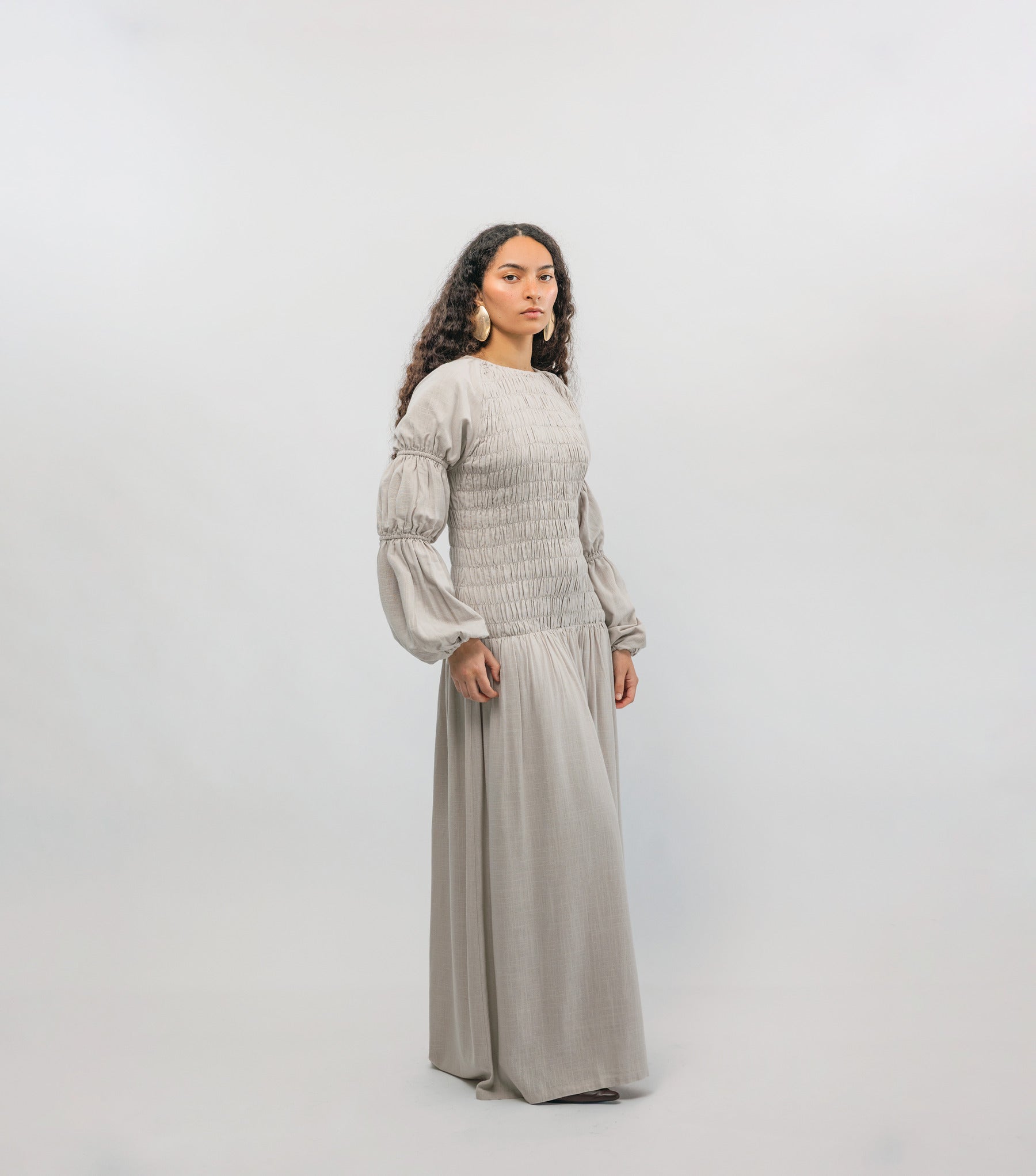 Woman wearing a light gray outfit on a white background
