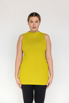 Woman wearing a sleeveless citrine yellow top on a white background