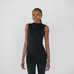 Woman wearing a black sleeveless top and leggings on a white background