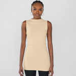 Woman wearing a beige sleeveless top against a plain background