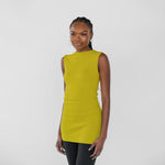 Woman wearing a sleeveless citrine yellow top on a white background
