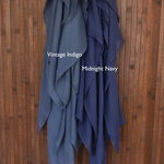Color comparison of two blue hijabs labeled 'Vintage Indigo' and 'Midnight Navy' on a wooden background.