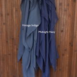 Color comparison of two blue hijabs labeled 'Vintage Indigo' and 'Midnight Navy' on a wooden background.