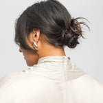 Person wearing a beige jacket with a plain background