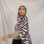 Model shown dynamically walking in the Zebra scarf, which is a deep berry and white striped scarf that resembles a Zebra. 