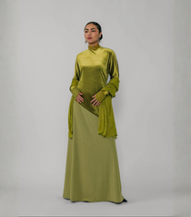 Woman wearing a green dress with a plain background