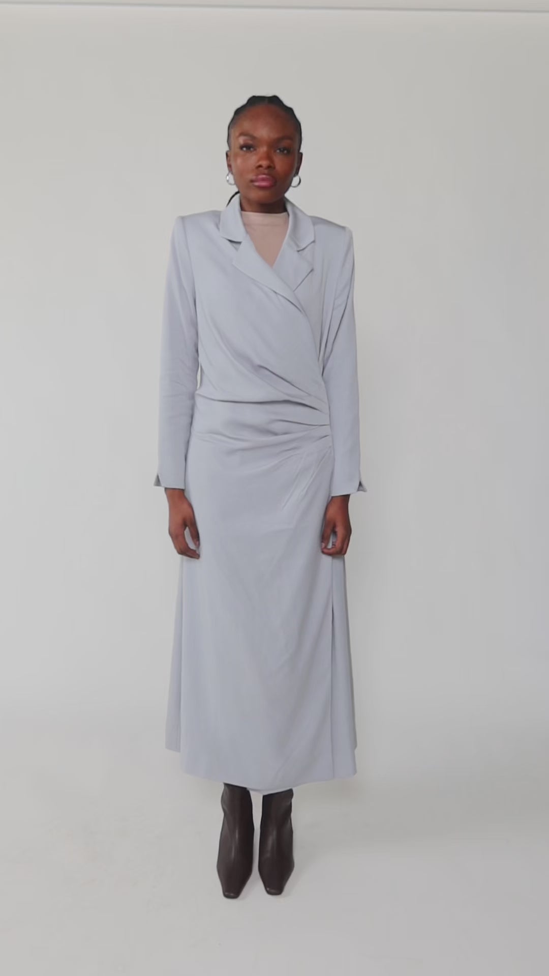 Woman wearing a light blue dress against a white background