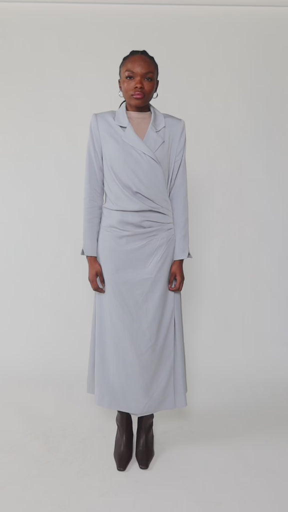 Woman wearing a light blue dress against a white background