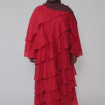 Woman wearing a red layered dress on a gray background