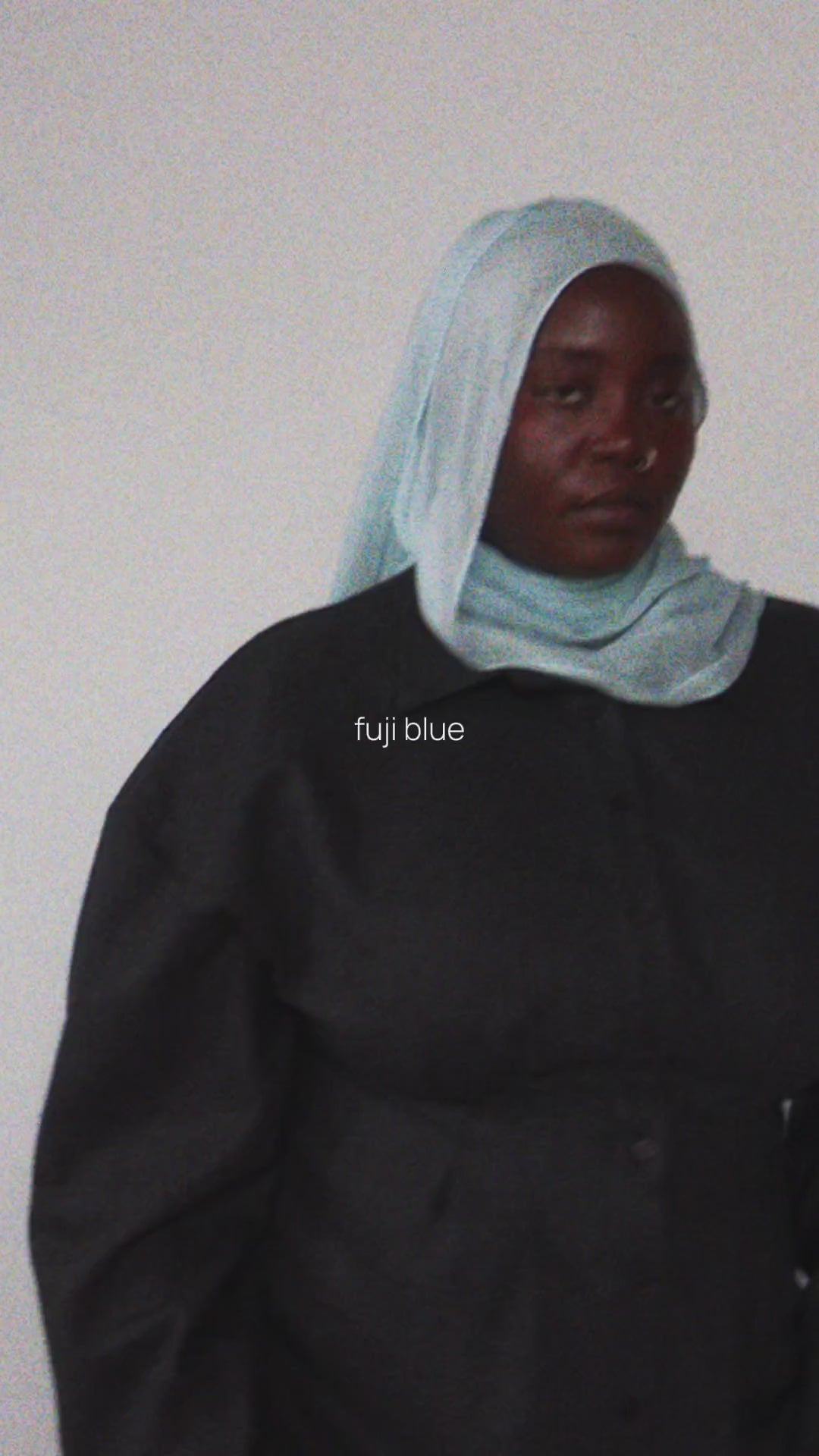 Woman wearing all black and a fuji blue hijab
