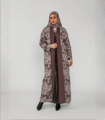 Woman wearing a long, patterned coat over a brown dress on a white background